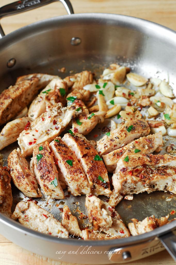 Chicken sliced in a pan covered with spices