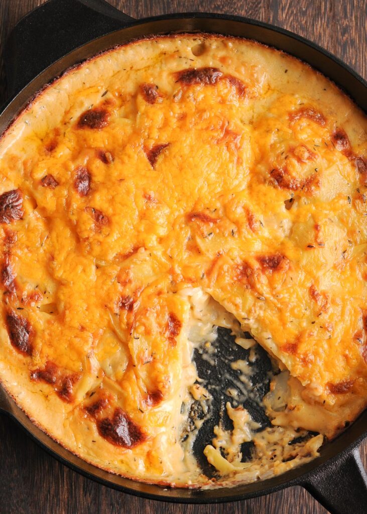 Cheddar, Thyme and Beer Potatoes Au Gratin in a cast iron pan