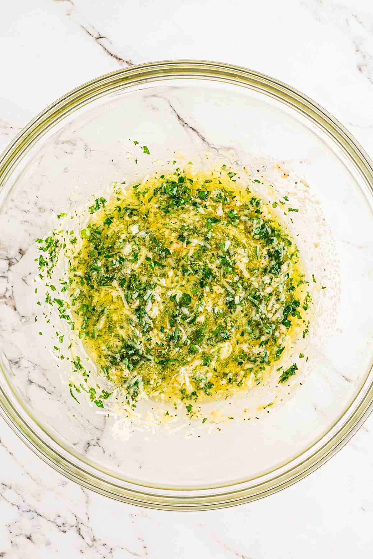 Homemade garlic parmesan butter sauce with minced garlic and Parmesan melting in a bowl