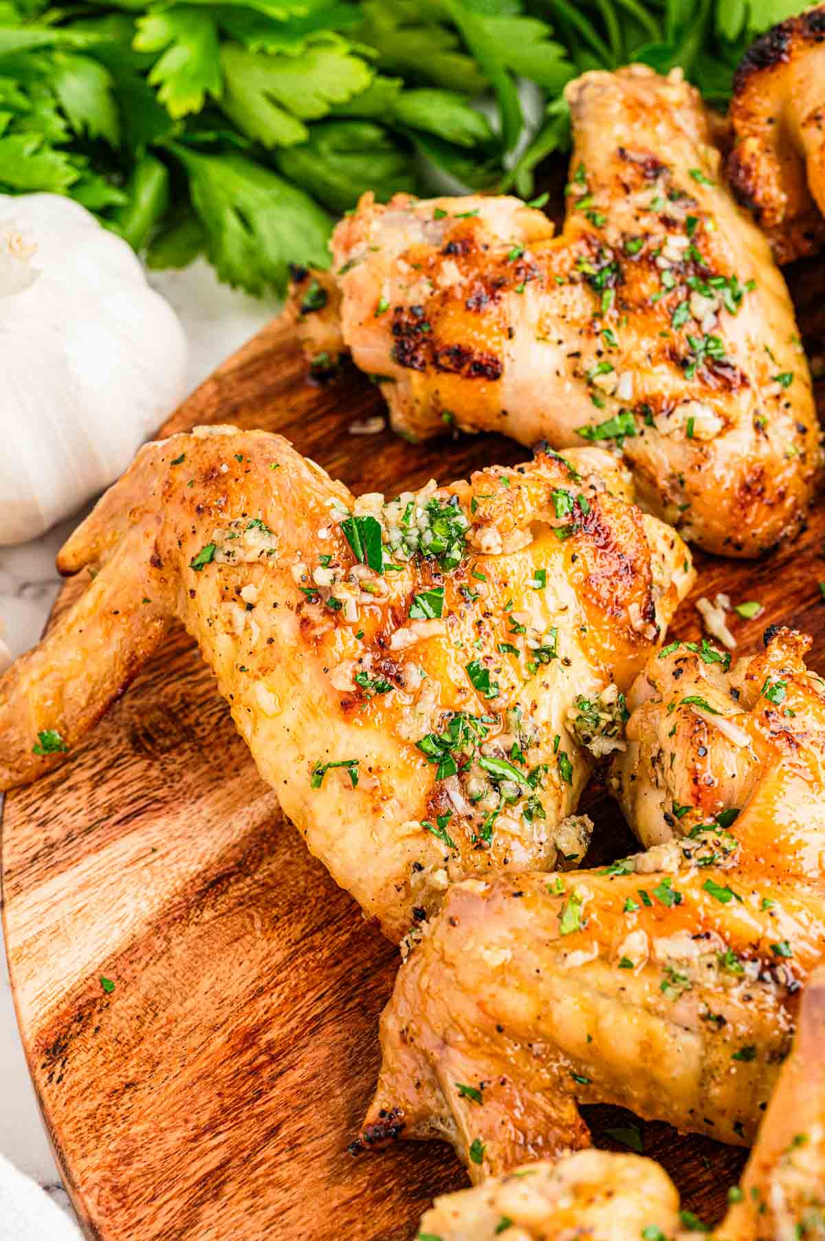 Close-up of crispy garlic parmesan chicken wings coated in buttery garlic parmesan sauce