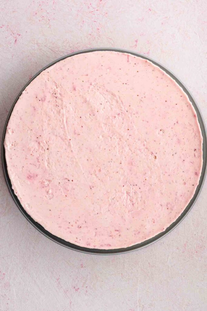strawberry filling poured inside spring form pan on top of graham cracker crust