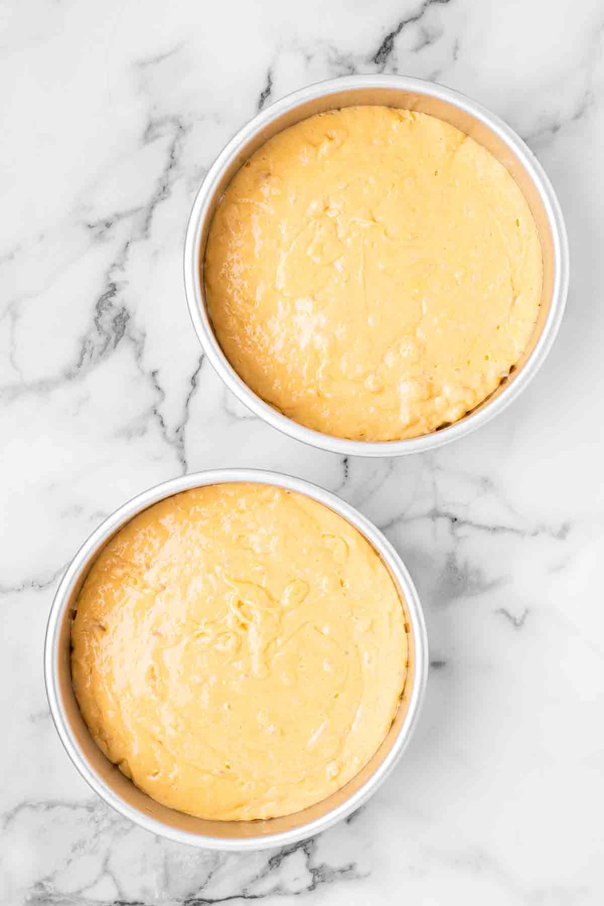 pina colada cake batter divided between two pans