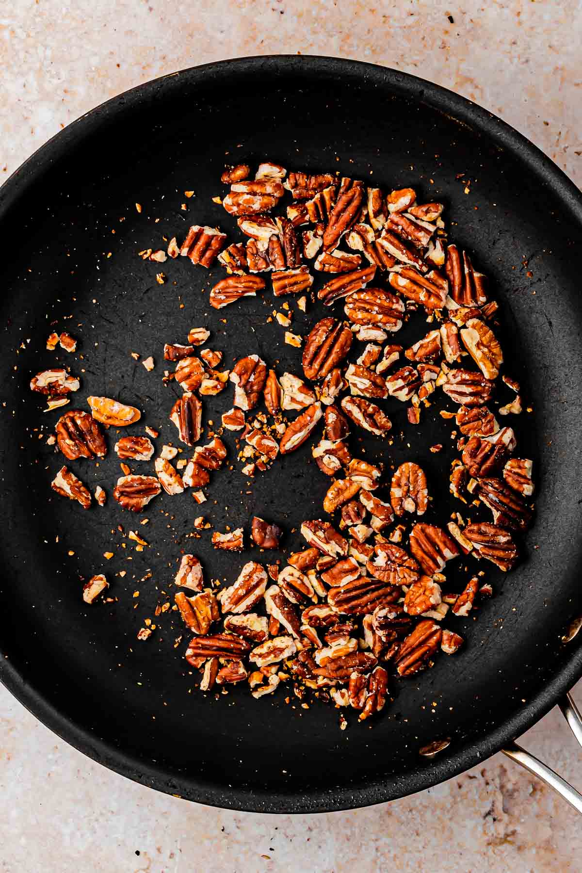 Toasted pecans inside cast iron pan