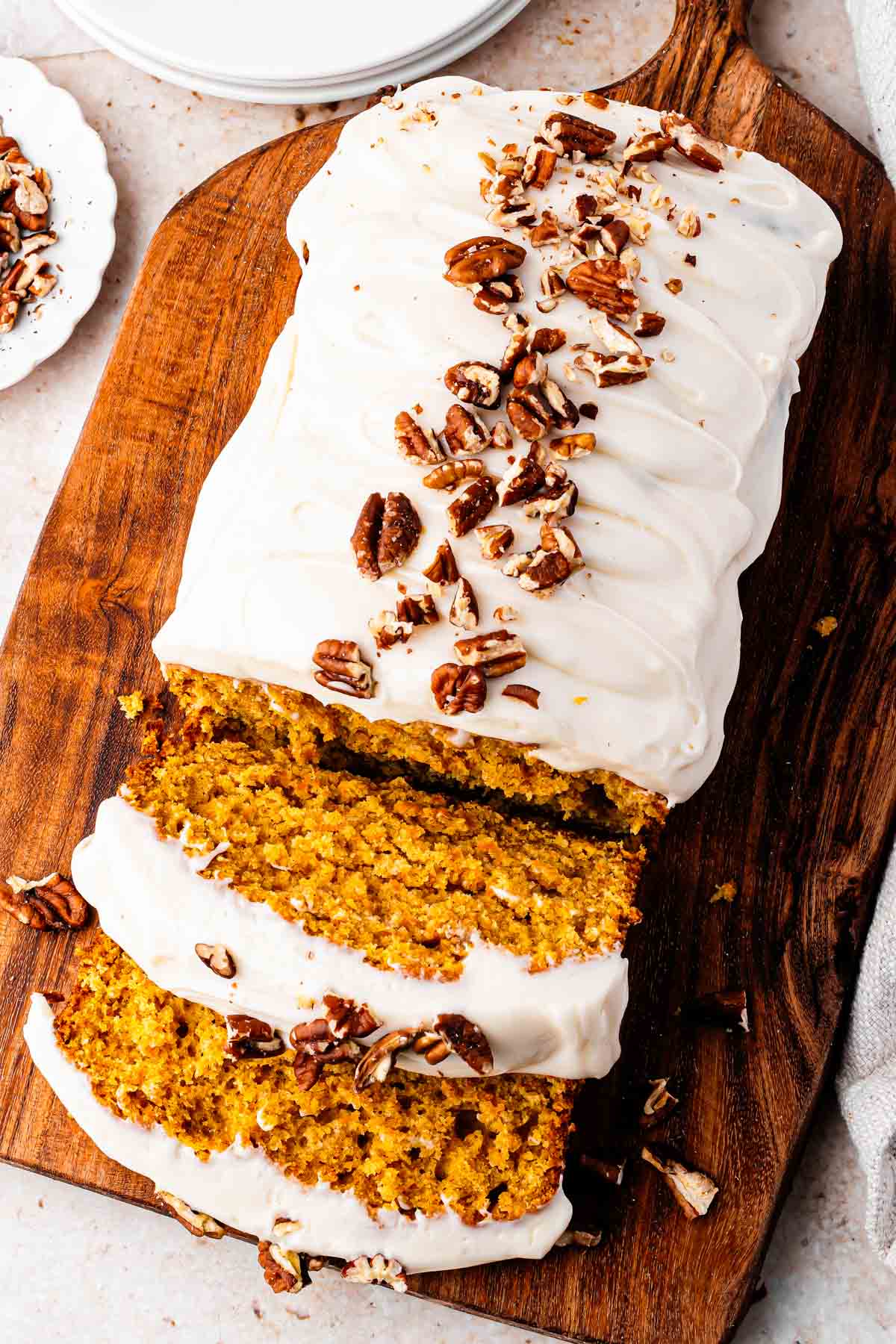 carrot cake loaf with cream cheese icing and toasted pecans