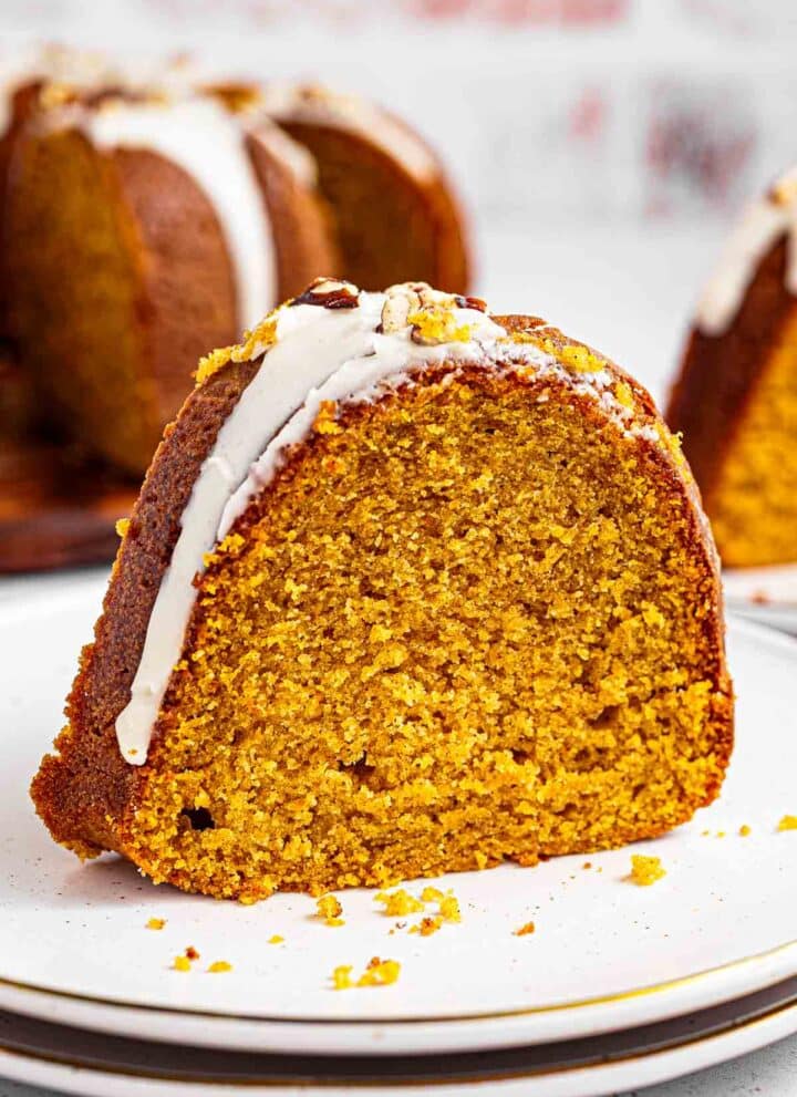 Extra moist pumpkin bundt cake topped with maple glaze and toasted pecans is easy to make and tastes like the holidays. It's a simple, homemade dessert packed with real pumpkin puree and filled with warm pumpkin pie spices: cinnamon, nutmeg, ginger, and cloves.