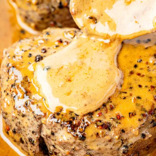 peppercorn steak with sauce being spooned on top