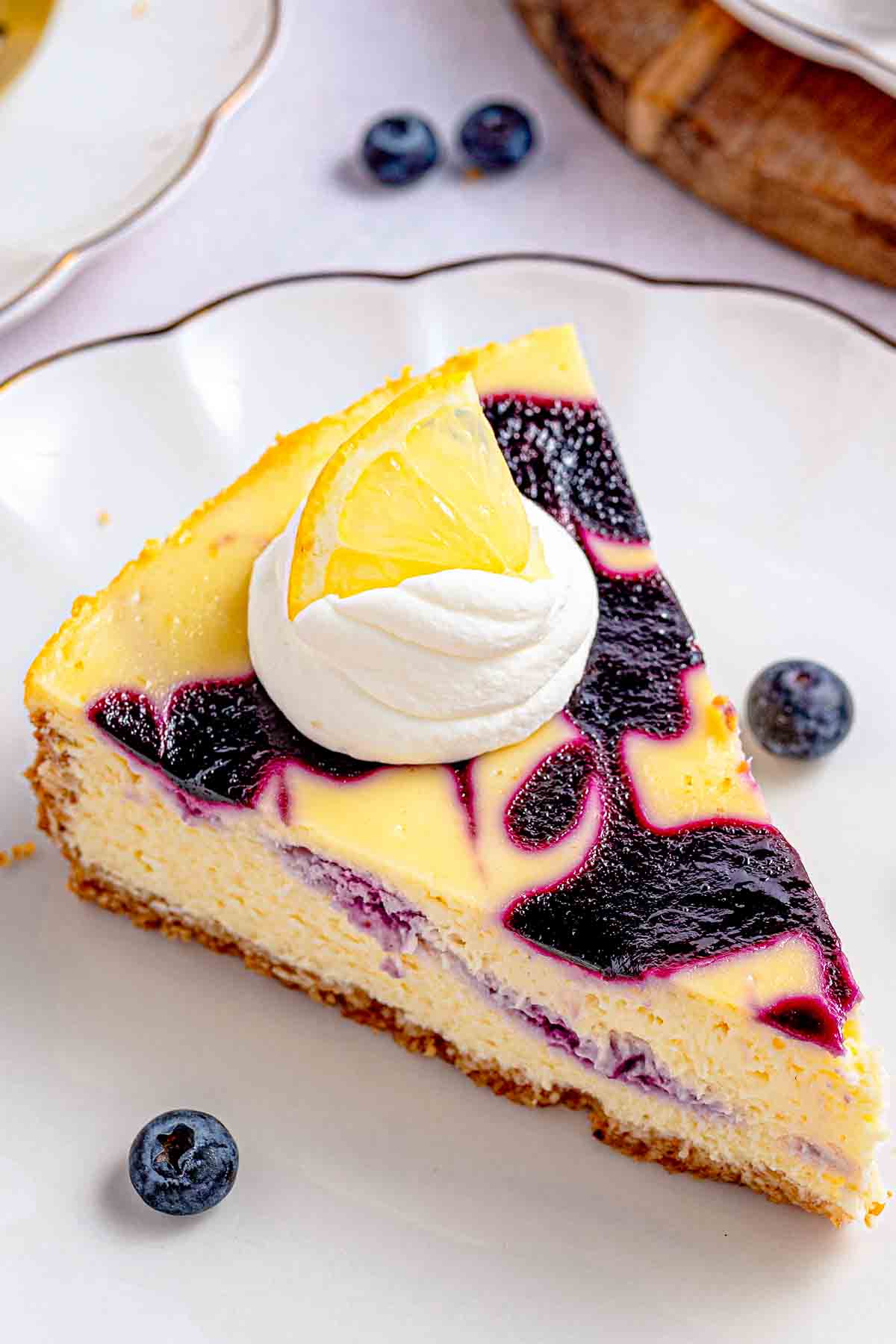 a slice of lemon blueberry cheesecake with fresh blueberry swirl