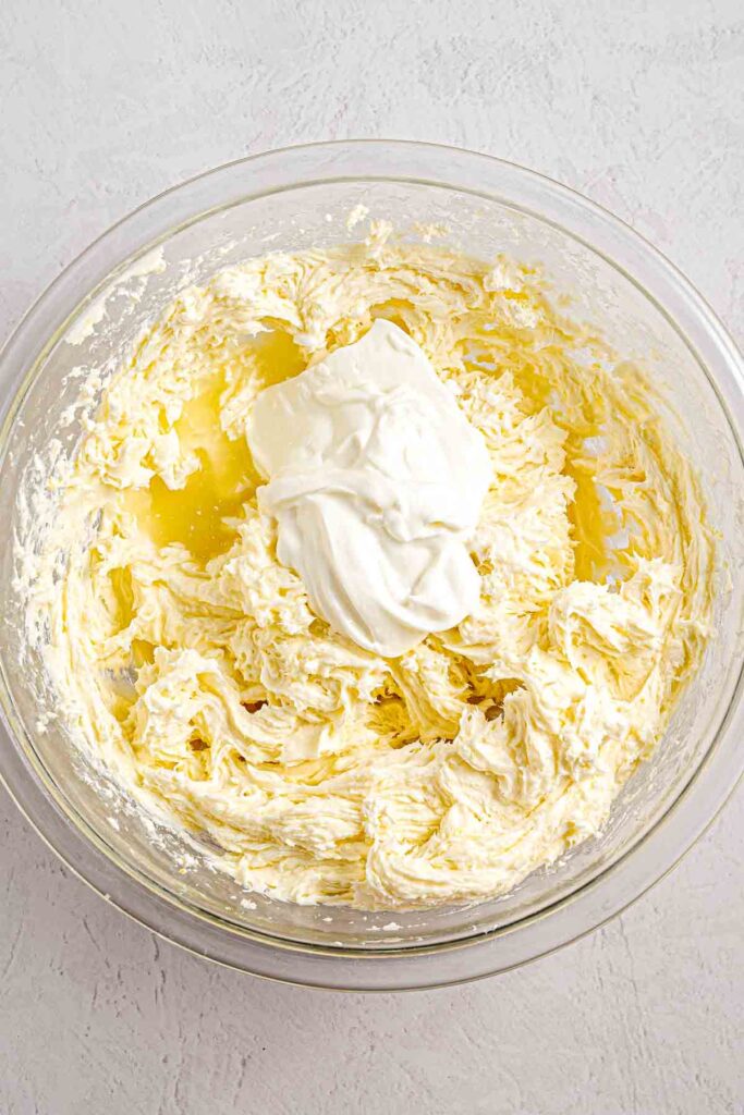 egg sour cream and cream cheese mixed with lemon in the bowl for the cheesecake filling