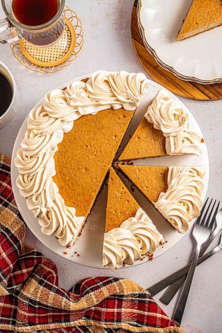 Baked espresso cheesecake with graham cracker crust, one slice removed, topped with espresso whipped cream.