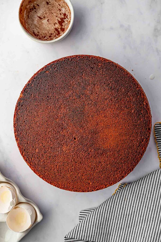 fully baked brazilian carrot cake being inverted onto a plate