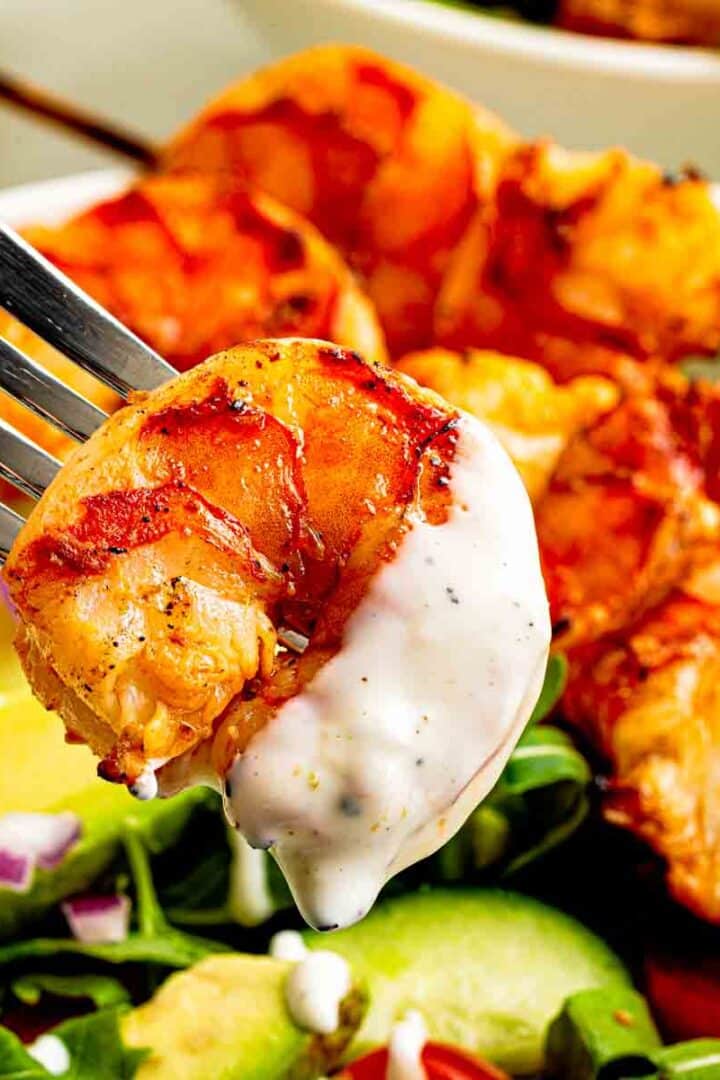 creamy lime sour cream dressing with black pepper on shrimp