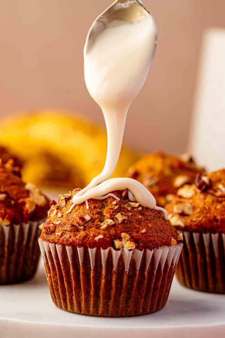 Maple icing in a spoon over a muffin at the perfect thick but pourable consistency for drizzling