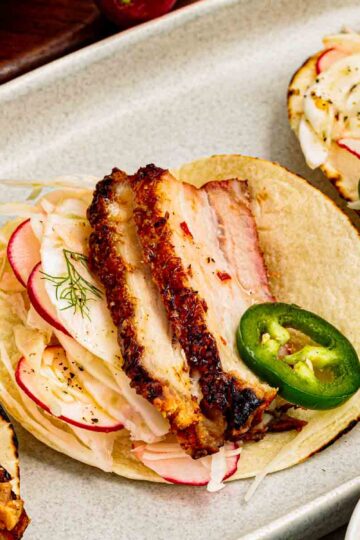 slow roasted pork belly tacos on corn tortillas with fennel radish slaw and sliced jalapenos
