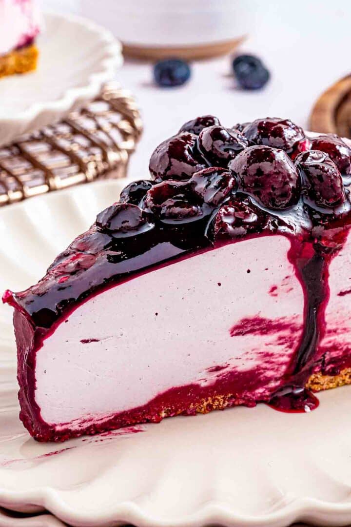 a slice of no bake blueberry cake with blueberry sauce on top