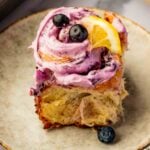 blueberry cinnamon rolls with blueberry cream cheese frosting in white baking dish