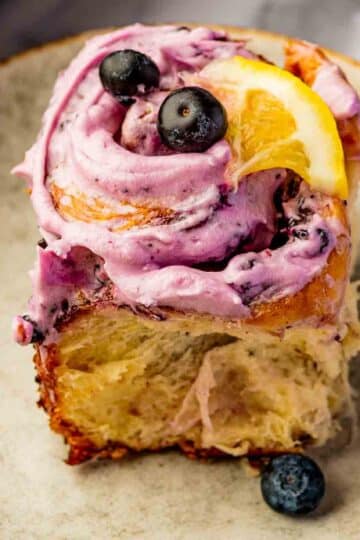 blueberry cinnamon rolls with blueberry cream cheese frosting in white baking dish