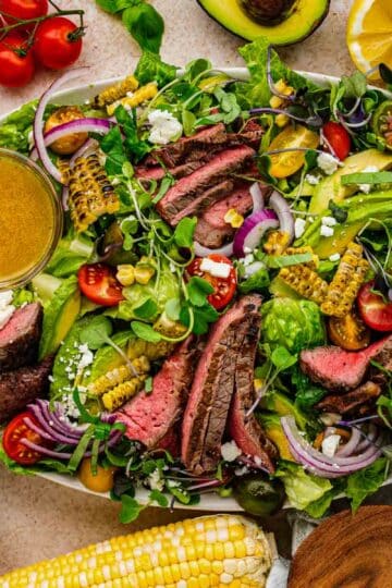 Steak salad with crosshatch grill marks, grilled corn, feta crumbles, and homemade vinaigrette"