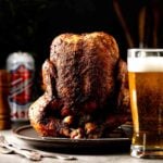 Smoked beer can chicken sliced open showing juicy breast meat and deeply seasoned crispy skin