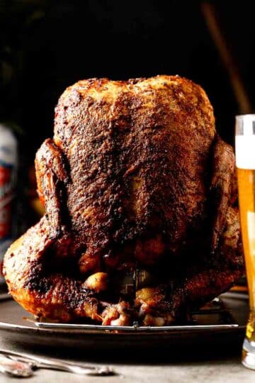 Smoked beer can chicken sliced open showing juicy breast meat and deeply seasoned crispy skin