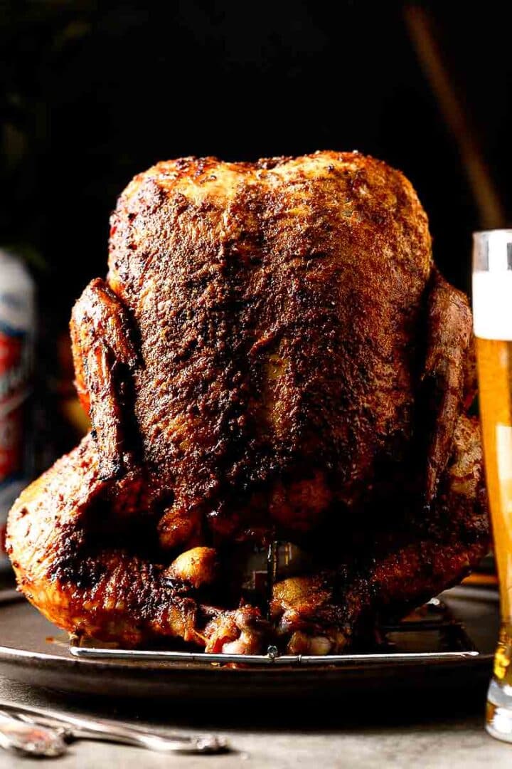 Smoked beer can chicken sliced open showing juicy breast meat and deeply seasoned crispy skin