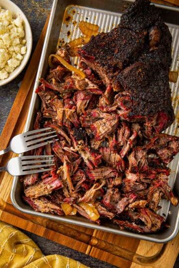 Cross-section of Tex-Mex smoked chuck roast showing a deep pink smoke ring beneath a thick black bark crust