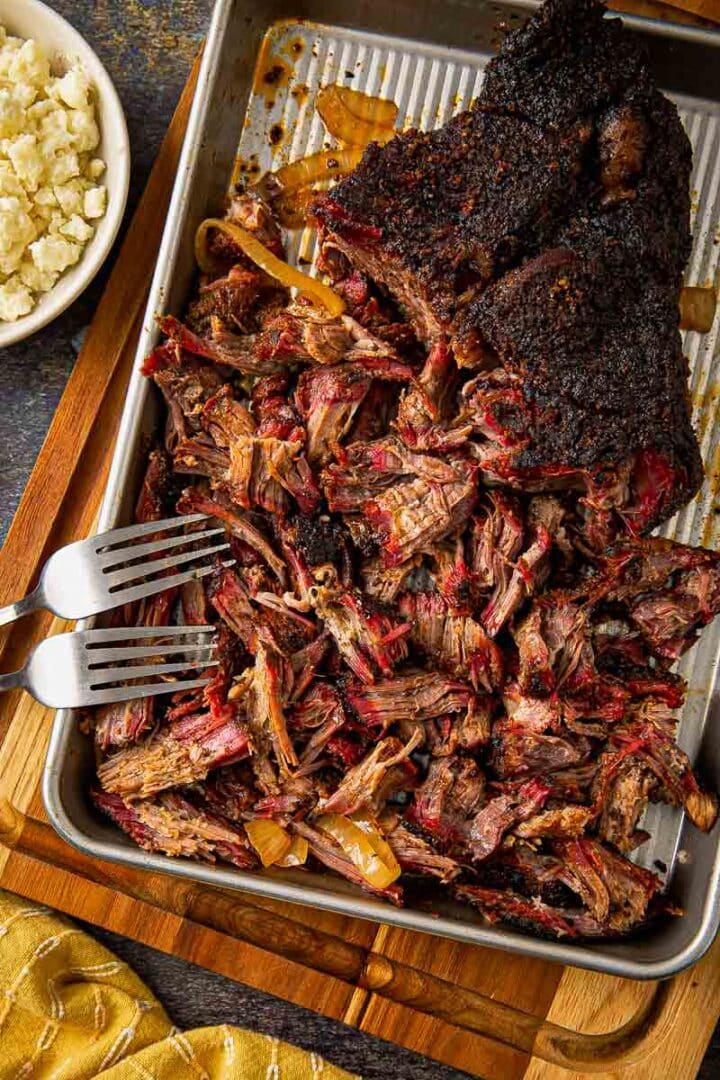 Cross-section of Tex-Mex smoked chuck roast showing a deep pink smoke ring beneath a thick black bark crust