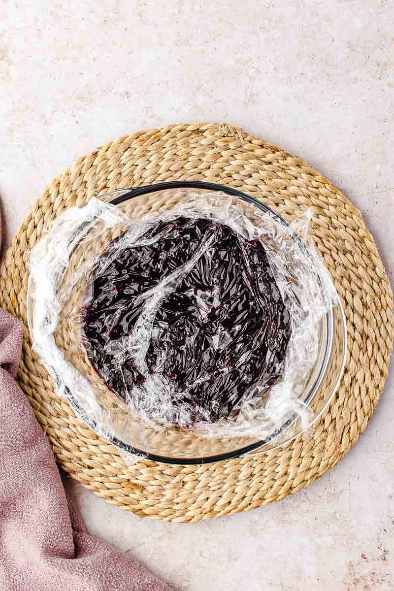 Finished blueberry filling transferred to a bowl with cling wrap pressed onto the surface before chilling"
