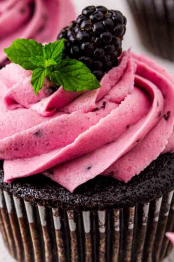 Filled chocolate blackberry cupcakes with a soft crumb, jam center, and berry buttercream swirl.