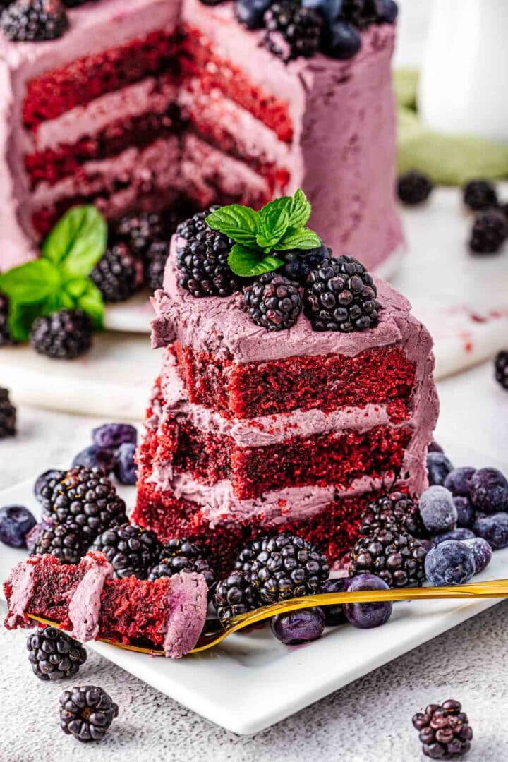 A decorated purple velvet cake finished with blackberries and blueberries.