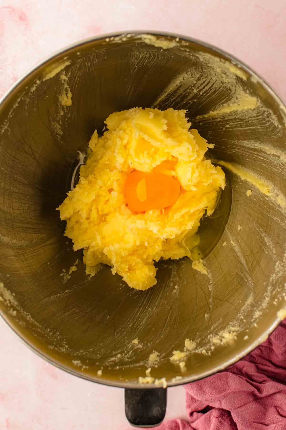 adding eggs to the creamed butter in the bowl