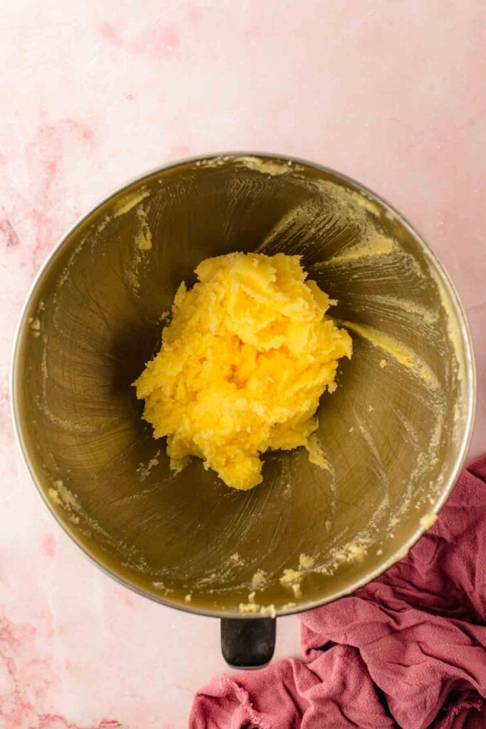 Pale, fluffy creamed butter and sugar in a mixing bowl for cherry bundt cake, after 4 minutes of beating