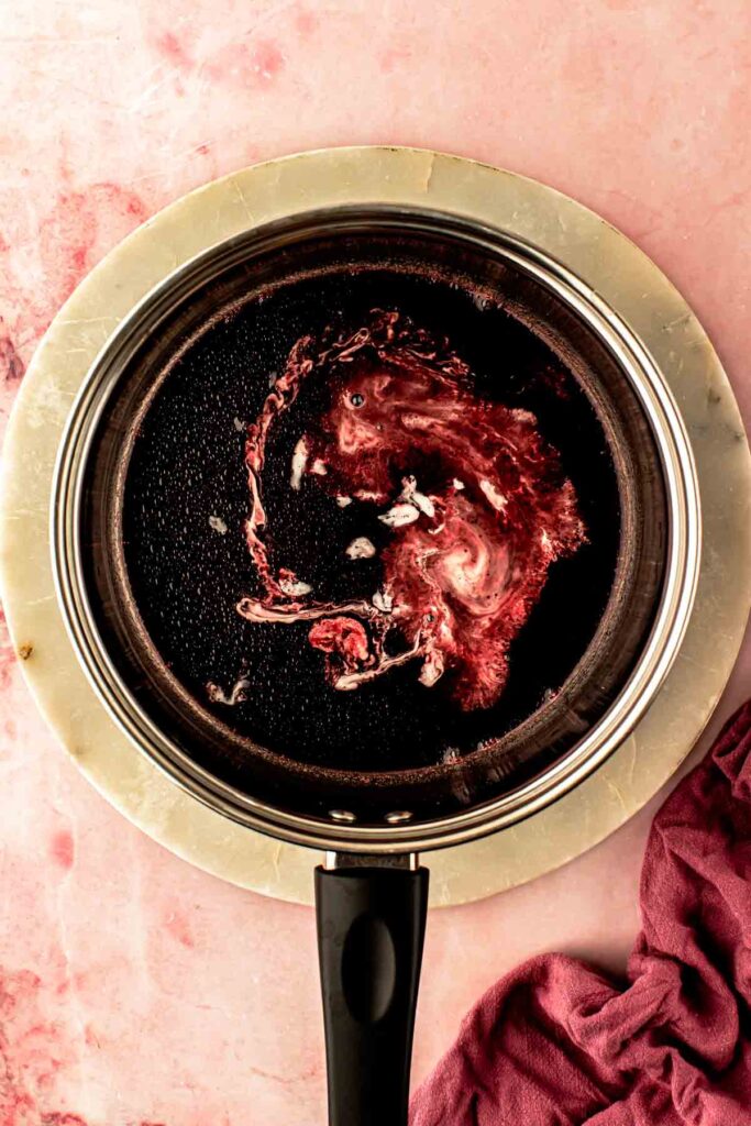 Cherry syrup whisked into powdered sugar to make pink cherry icing for a cherry bundt cake