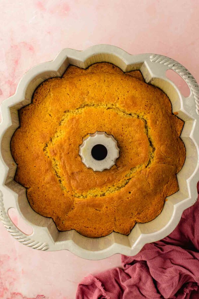 Baked cherry bundt cake cooling in the pan on a wire rack before being inverted
