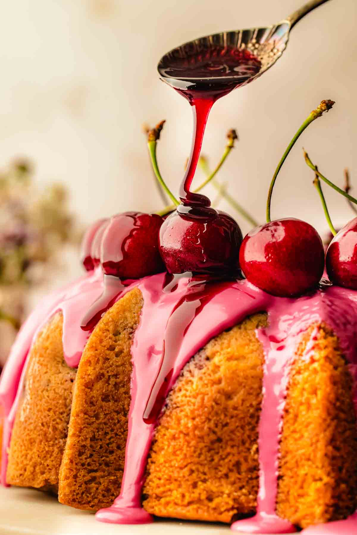 Close-up of cherry syrup drips running down the ridges of a fresh cherry bundt cake