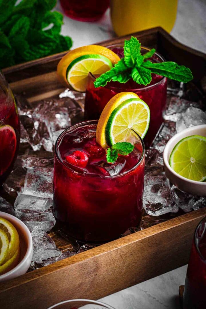 Raspberry sangria mocktail poured over ice with fruit in a clear glass
