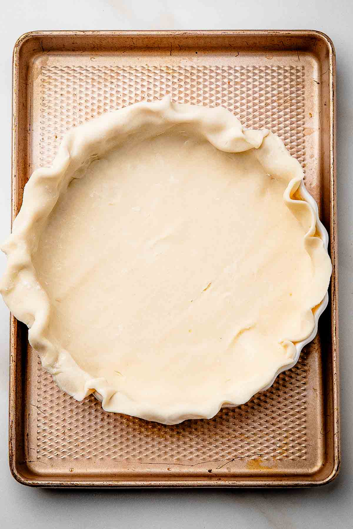 Unbaked pie crust pressed into a 9-inch pie plate with rustic, uneven edges before adding maple filling