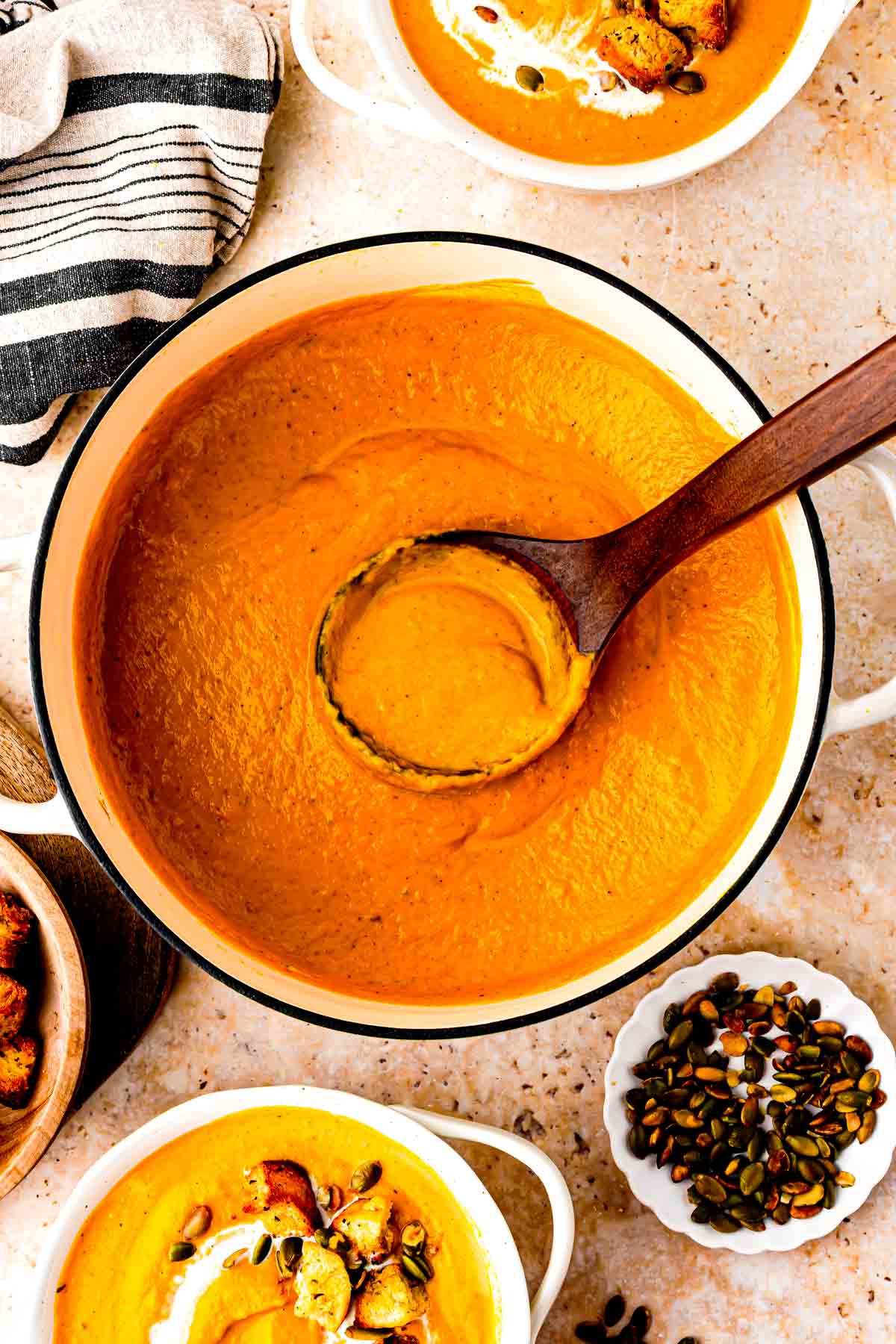 butternut squash pumpkin sweet potato soup with a ladle full of orange goodness