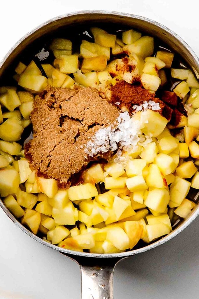 sugar, spices and sliced apples in the saucepan