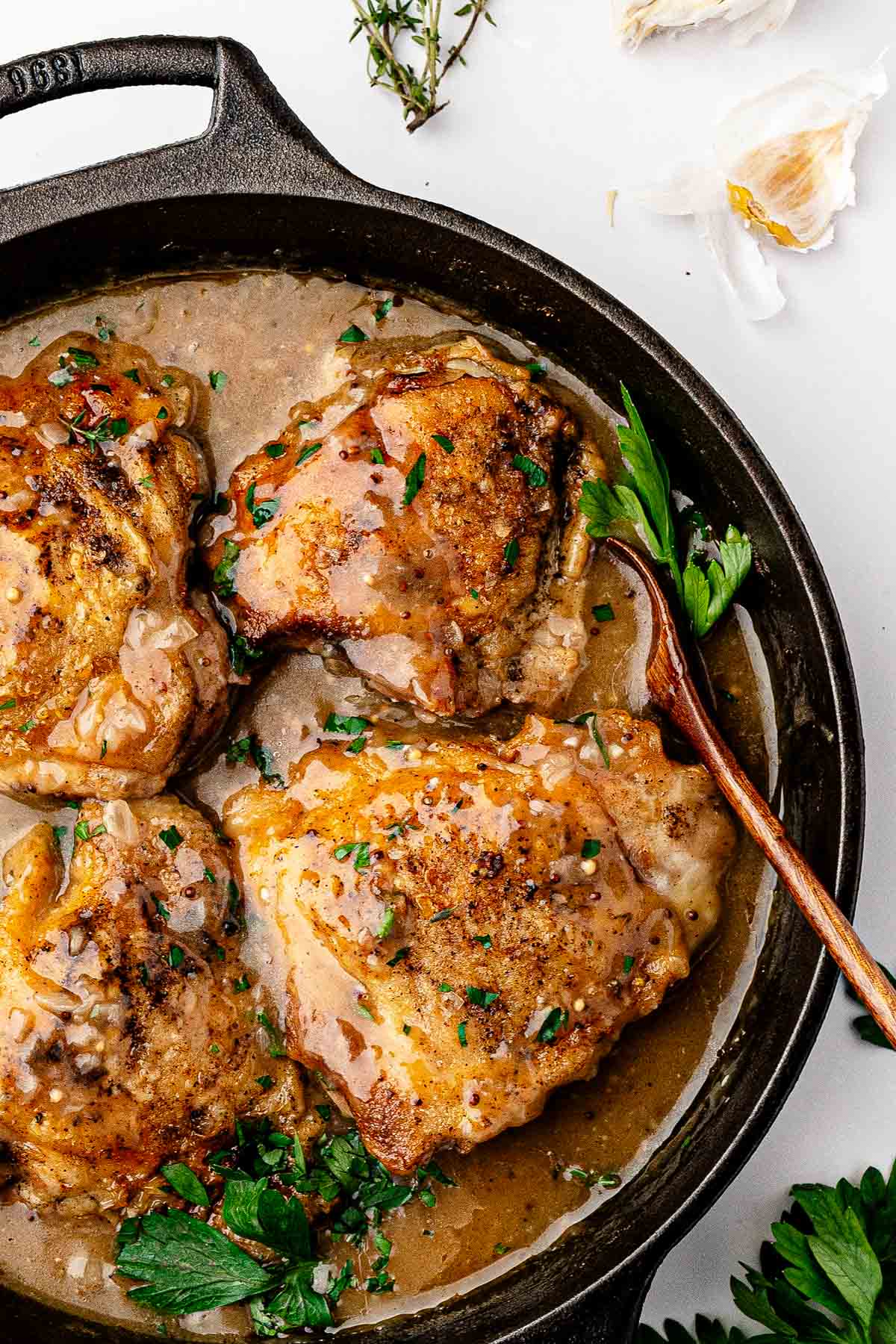 Butter melting into the beer sauce in the skillet to finish the braised chicken thighs
