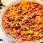 Bowl of cabbage roll soup with ground pork, rice, and chopped parsley