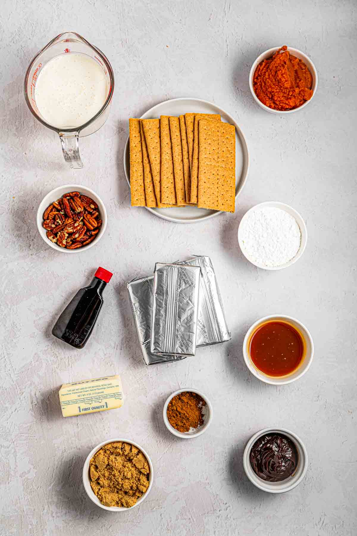 Ingredients for no-bake pumpkin turtle cheesecake laid out on a counter