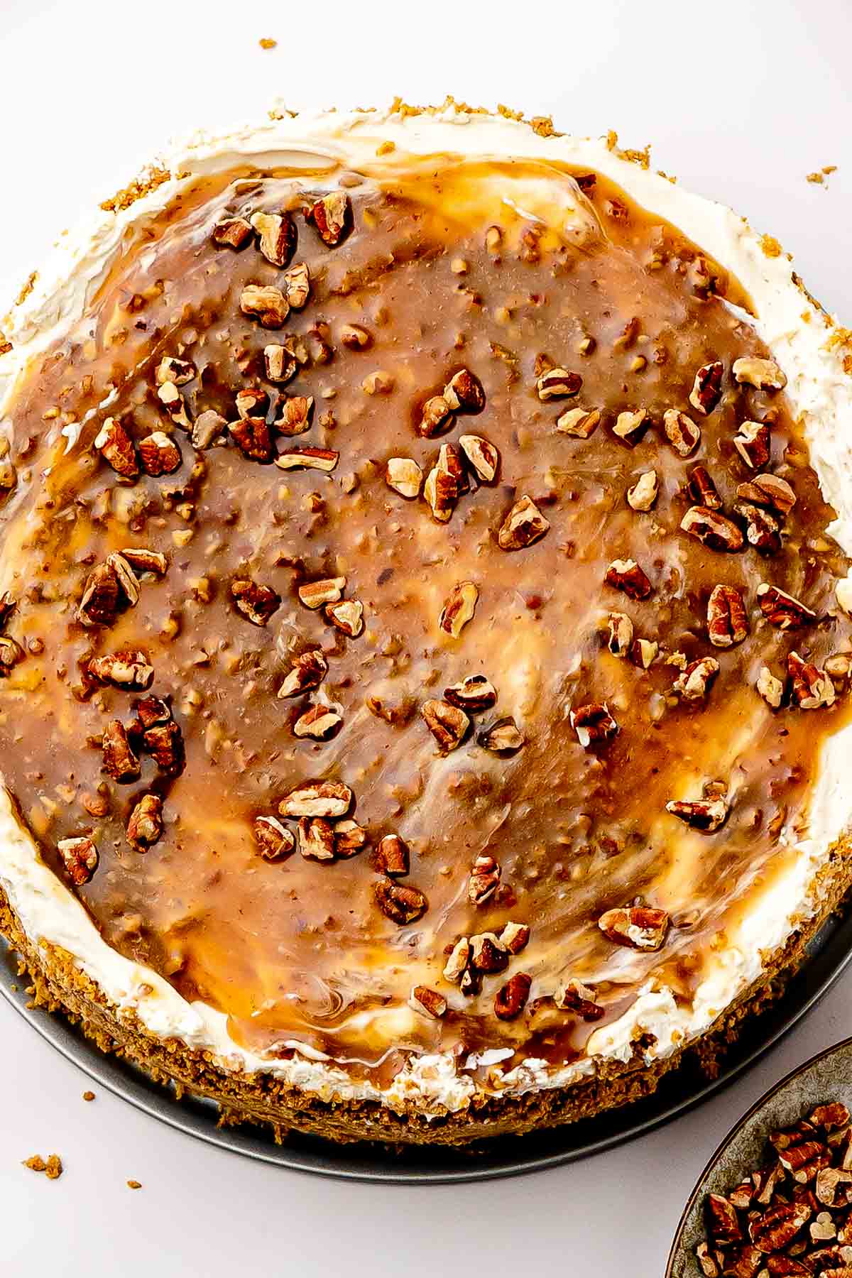 Topping on cheesecake: Spooning warm maple-butter pecan topping over the chilled cheesecake