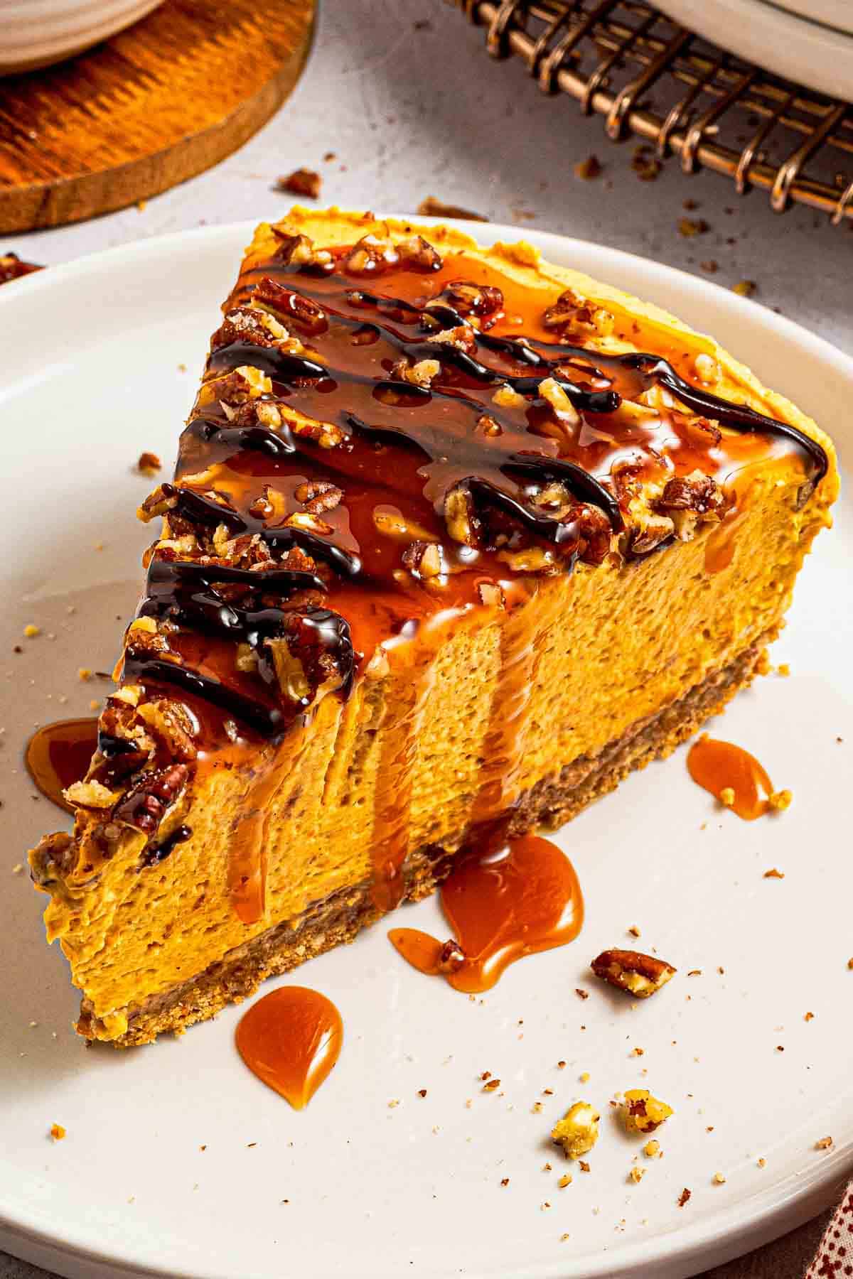 No-bake pumpkin turtle cheesecake topped with pecans, caramel and hot fudge on a plate