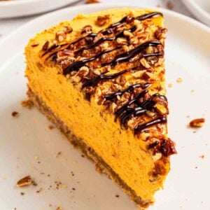 No-bake pumpkin turtle cheesecake slice with caramel, pecans and fudge