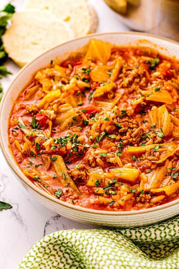 Bowl of cabbage roll soup with ground pork, rice, and chopped parsley