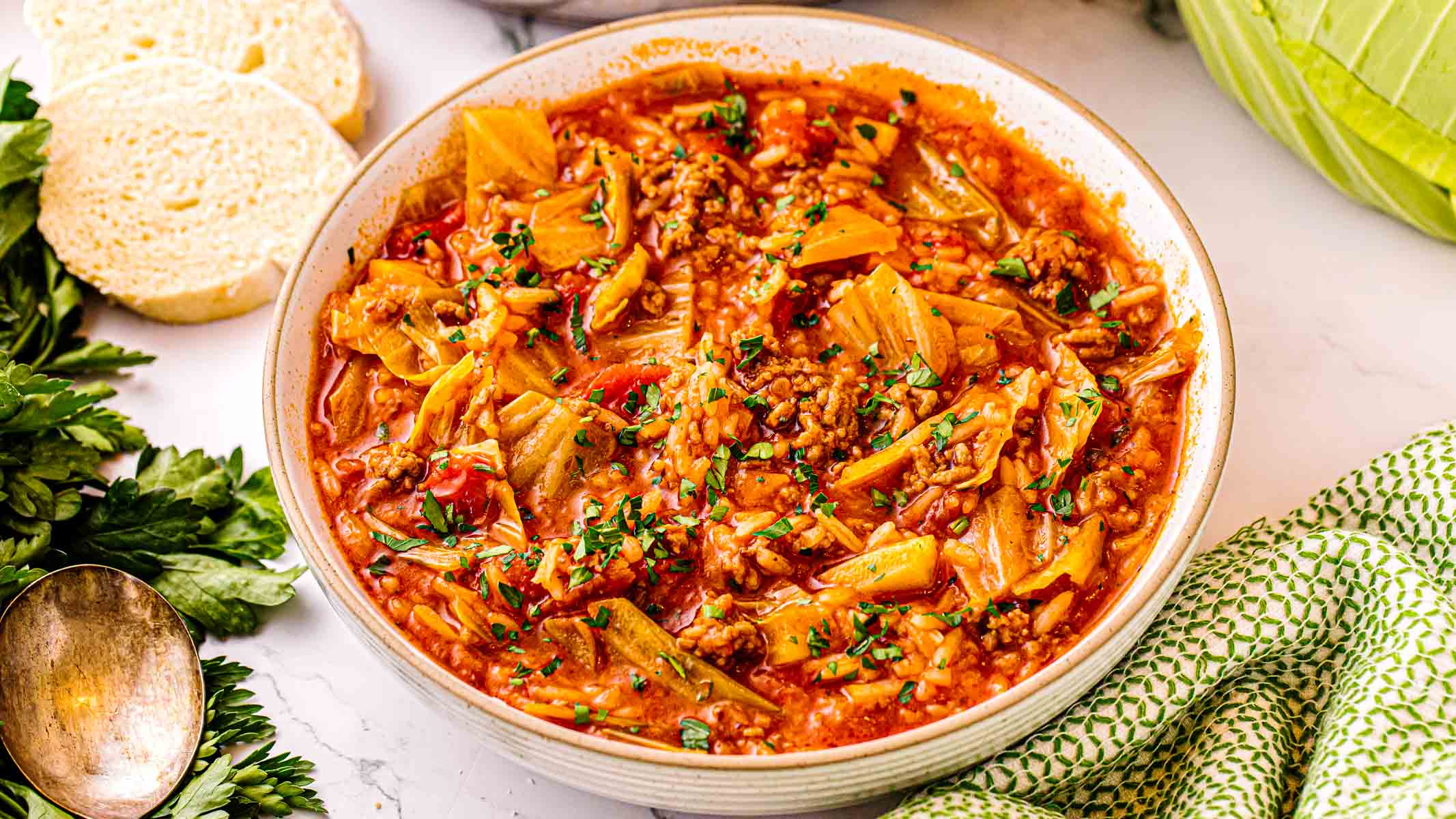 Bowl of cabbage roll soup with ground pork, rice, and chopped parsley