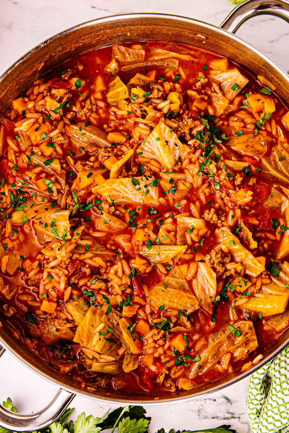 Dutch oven full of cabbage roll soup with cabbage, rice, and tomato broth