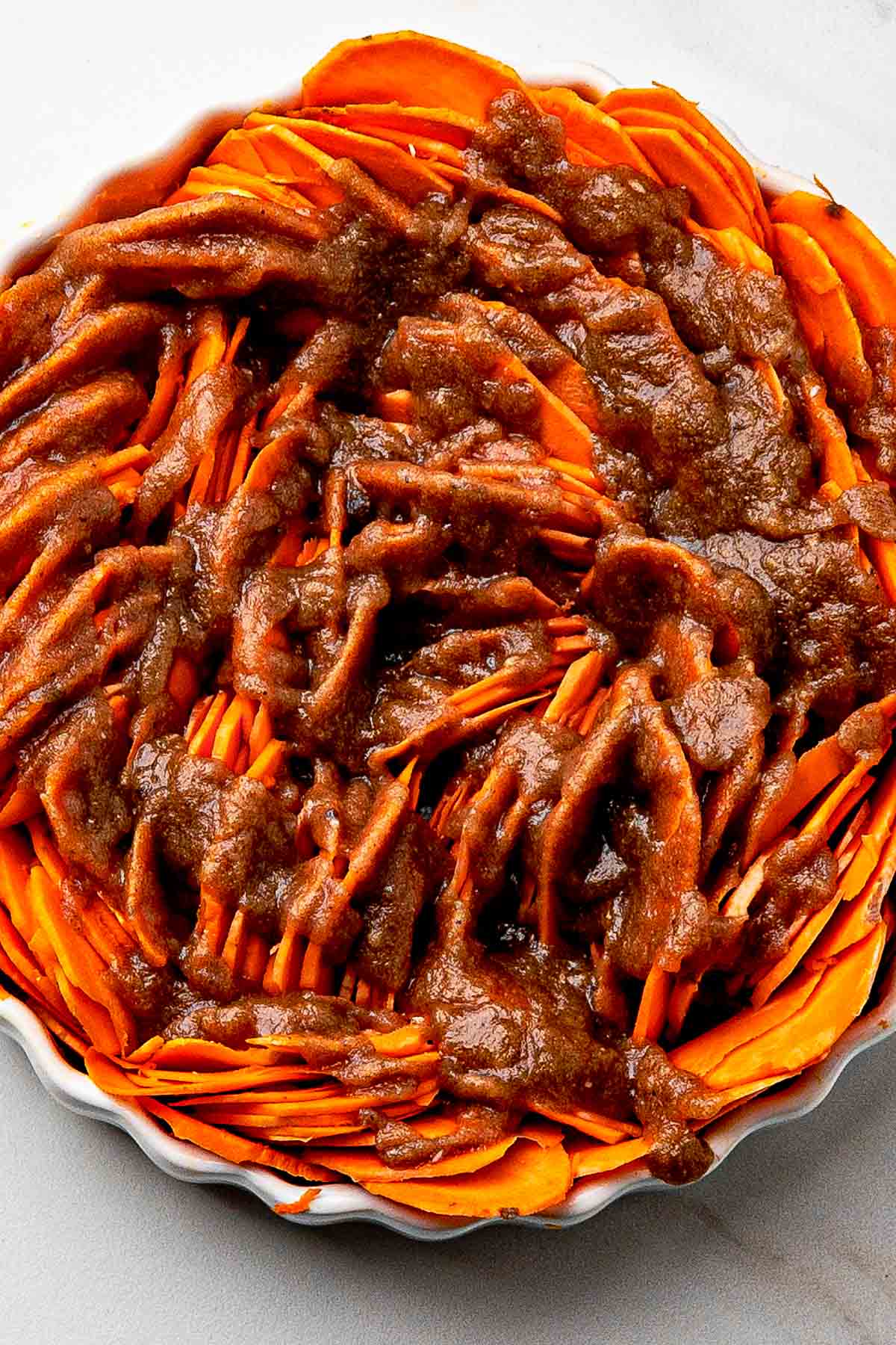 maple syrup on top of sliced sweet potatoes