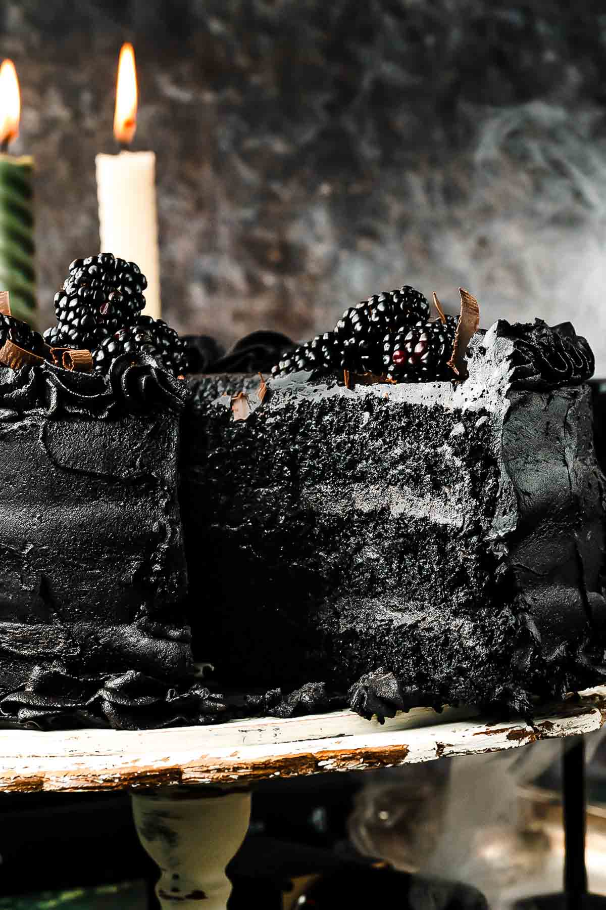 Black velvet cake made without food coloring, frosted in black cocoa buttercream and topped with blackberries