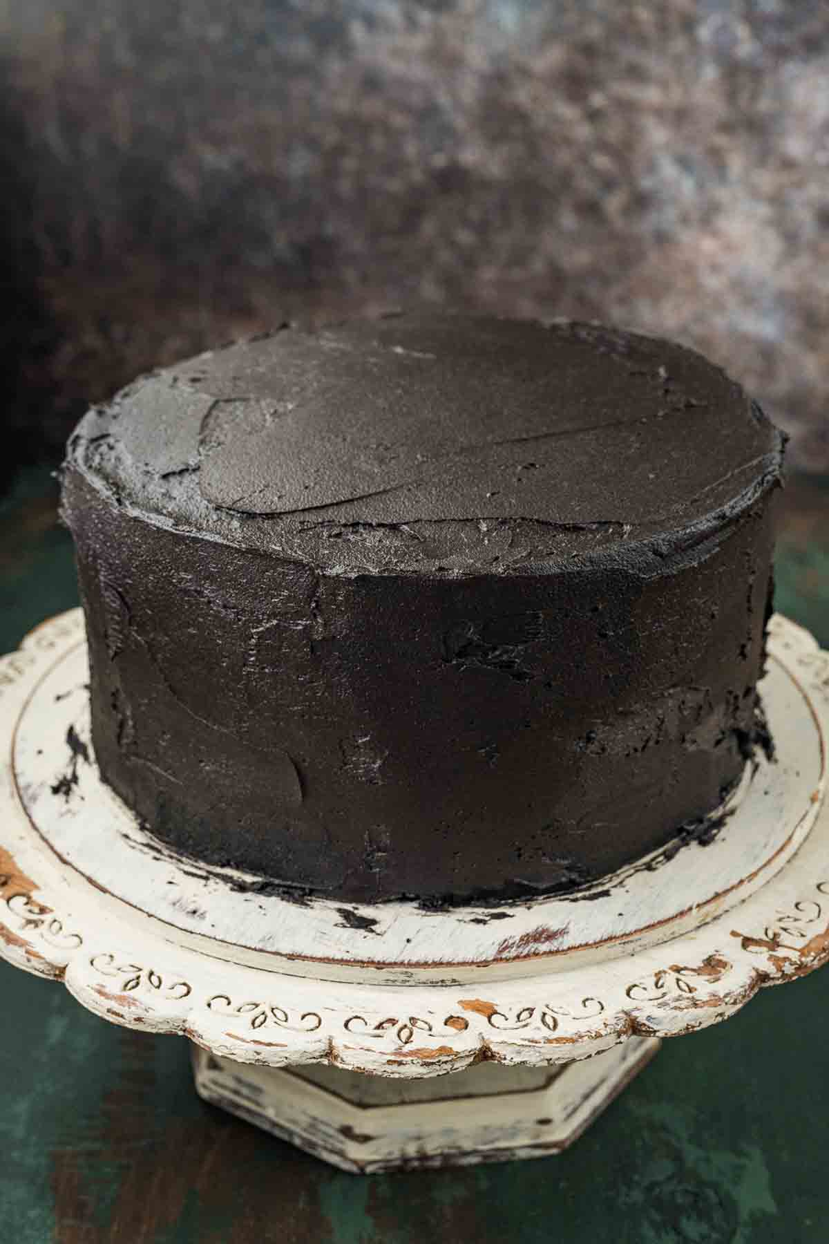 Black velvet cake covered with a thin crumb coat of buttercream before chilling